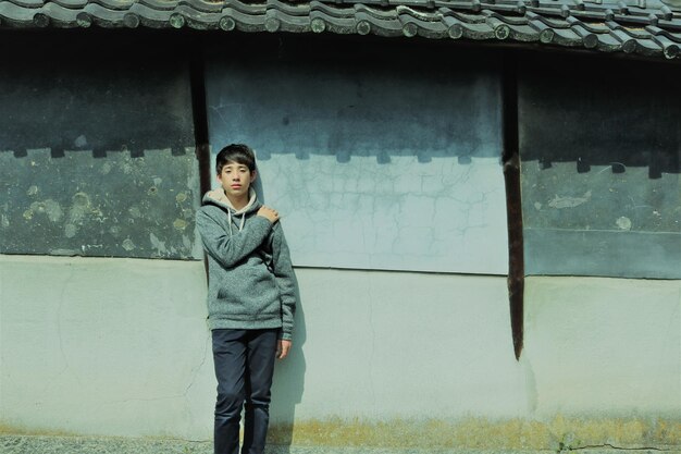 사진 건물 에 맞대고 서 있는 소년 의 초상화