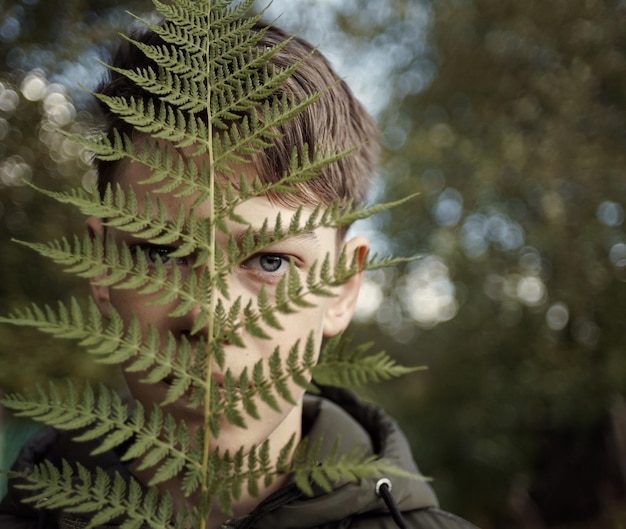 Фото Портрет мальчика с растениями на открытом воздухе