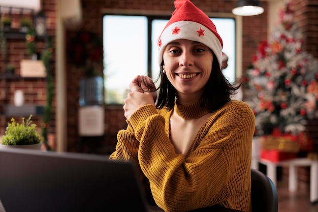 クリスマス ライトとツリーで飾られた空間で企業の仕事を楽しんで、お祝いのオフィスで働く実業家の肖像画。スタートアップの職場でのクリスマスの休日の装飾と季節の装飾品。