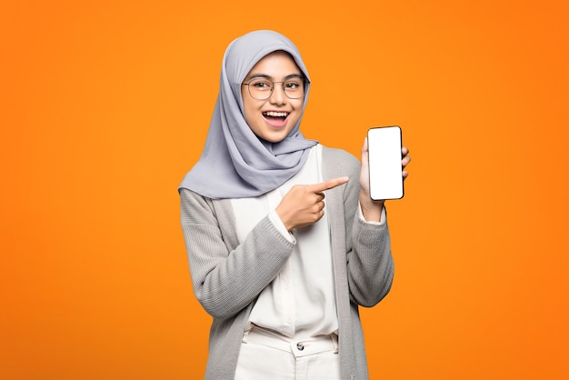 写真 スマートフォンを指す陽気な美しいアジアの女性の肖像画