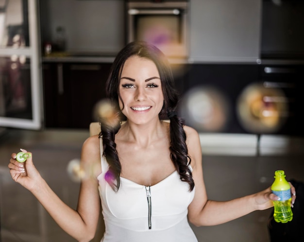 Фото Портрет веселой молодой женщины с пузырьками дома