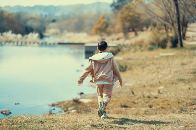 写真 湖の近くで走っている子供の肖像画