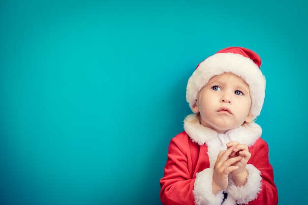 サンタクロースの衣装を着ている子供の肖像画。クリスマスの時期に楽しんでいる子供。メリークリスマスのコンセプト