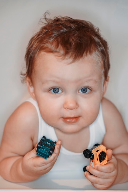 Фото Портрет милого мальчика с игрушечными машинами