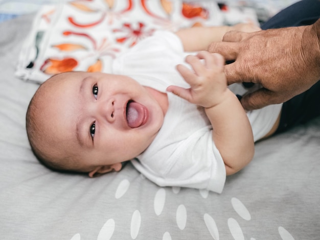 写真 家のベッドで笑っている可愛い赤ちゃんの肖像画