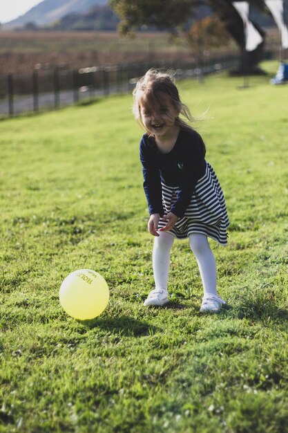 写真 フィールドでボールで遊ぶ可愛い女の子の肖像画