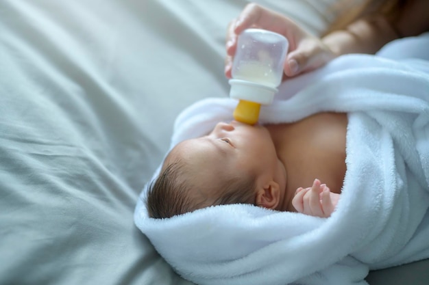 사진 우유 병을 마시는 귀여운 갓 태어난 아기의 초상화