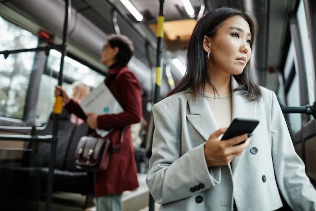 写真 公共交通機関とholで旅行中にバスの窓を見ているエレガントなアジアの女性の肖像画...