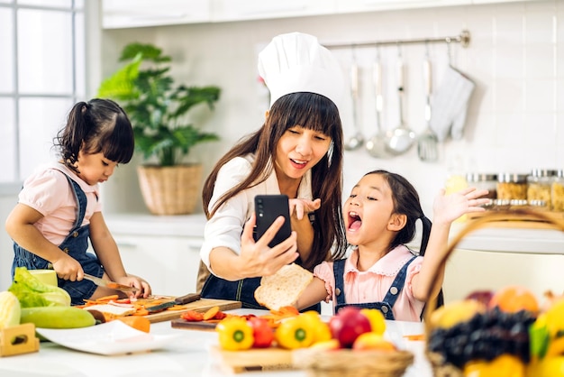 사진 행복 한 사랑 아시아 가족 어머니와 작은 아시아 여자 딸 아이의 초상화 부엌에서 신선한 야채 샐러드와 샌드위치 재료와 함께 음식을 요리하는 데 도움이 재미