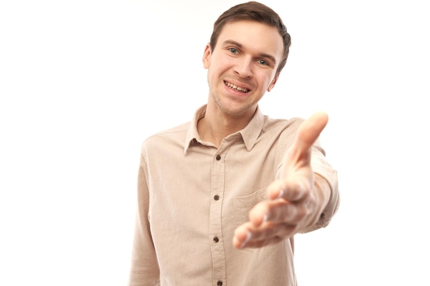 Фото Портрет дружелюбного позитивного молодого мужчины выбирает вас, указывает пальцем на камеру, изолированную на белом фоне