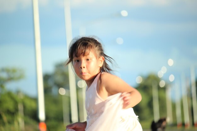 写真 空に向かって立っている女の子の肖像画