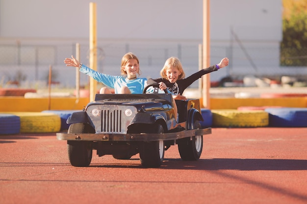 写真 おもちゃの車に乗っている妹の女の子の肖像画