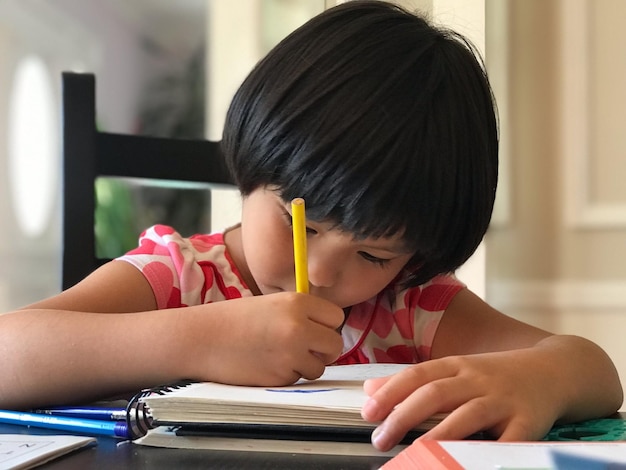 写真 ノートブックに書いている女の子の肖像画