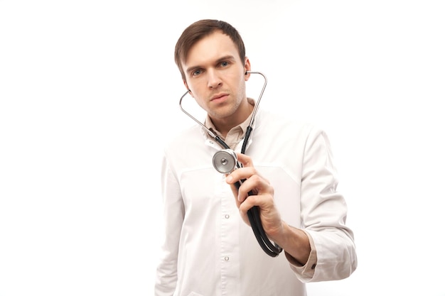 Фото Портрет красивого врача в белом медицинском халате со стетоскопом на белом фоне с копией пространства