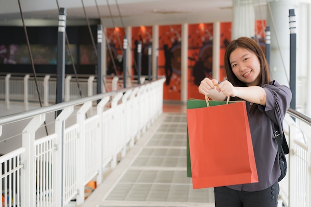 写真 色付きバッグで買い物に幸せなアジアの女の子の肖像画。