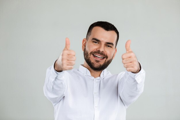 Портрет счастливого бородатого мужчины, показывающего большой палец вверх