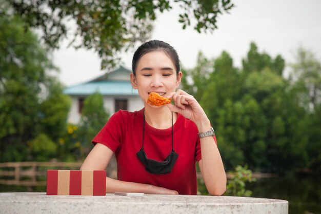 写真 木の向こうのテーブルに座っている幸せな女の子の肖像画