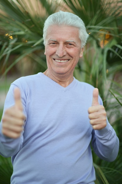 Фото Портрет счастливого зрелого человека, жестикулирующего большими пальцами руки вверх
