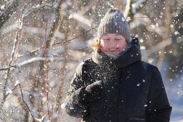 写真 冬の日に森を歩く幸せな若い女性の肖像画