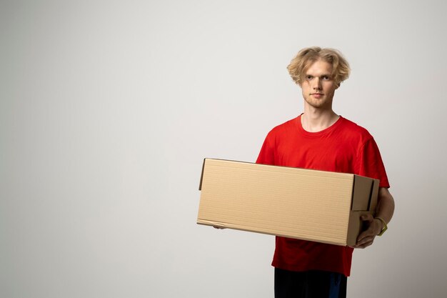 Фото Портрет человека, держащего коробку, стоящего на белом фоне