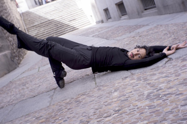 Фото Портрет человека, лежащего на тротуаре.
