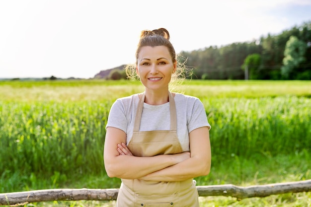 Фото Портрет зрелой улыбающейся женщины-фермера в поле