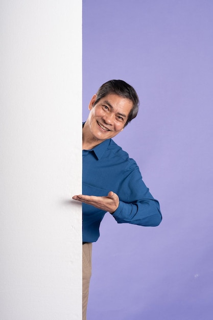 Фото Портрет азиатского бизнесмена средних лет, позирующего на фиолетовом фоне