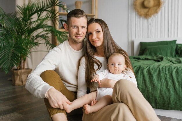 写真 両親と6ヶ月の赤ん坊が一緒に過ごしている肖像画