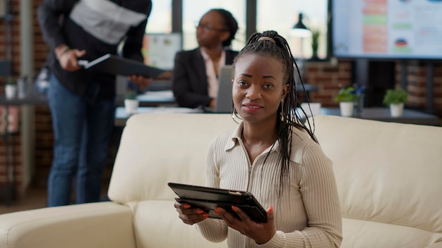ビジネスの成長を計画するためのテクノロジーを備えたガジェットを使用して、デジタルタブレットでインターネットを閲覧しているサラリーマンの肖像画。戦略を開発するためにデバイス画面を見ている女性従業員。