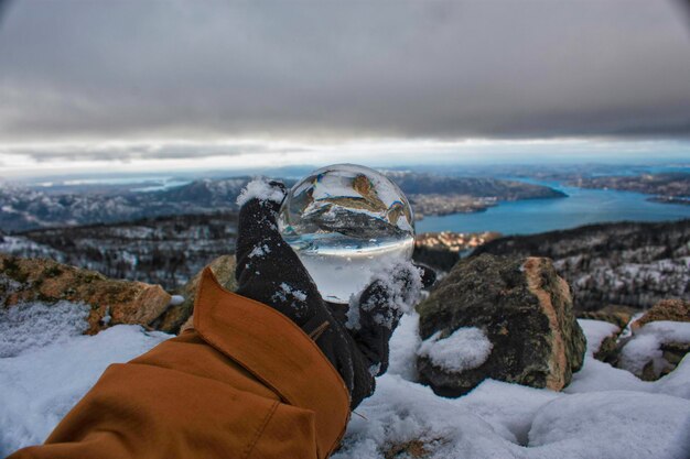 写真 空に照らされた雪に覆われた土地の人の手の肖像画