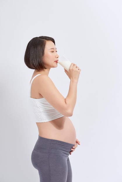 Портрет беременной женщины с молоком в стакане дома
