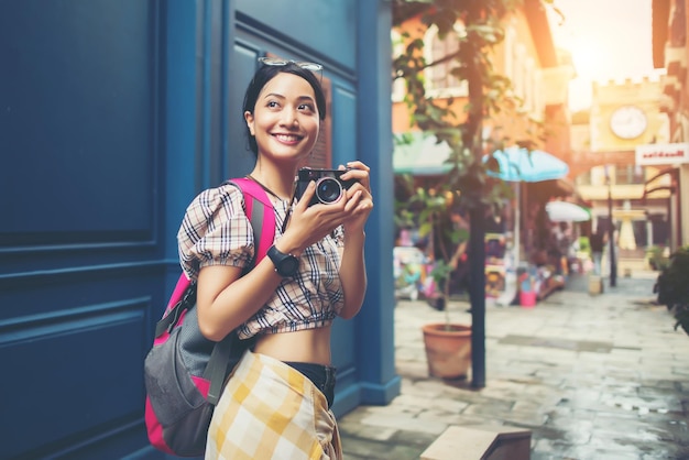 写真 カメラのタベリングで街で楽しんでいる美しい若いヒップスター女性の肖像画