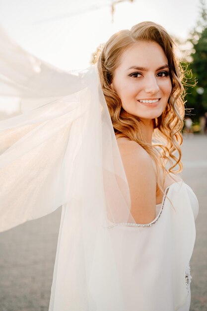 Фото Портрет улыбающейся невесты, стоящей на открытом воздухе