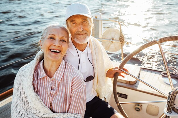 Фото Портрет улыбающейся пары, сидящей на парусной лодке в море