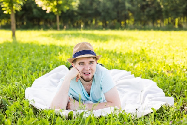 写真 草の中に横たわっている笑顔の男の肖像画