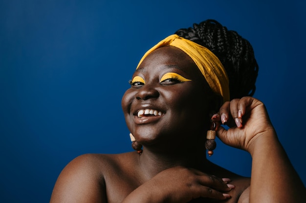 Фото Портрет улыбающейся африканской женщины с красивым макияжем и сережкой