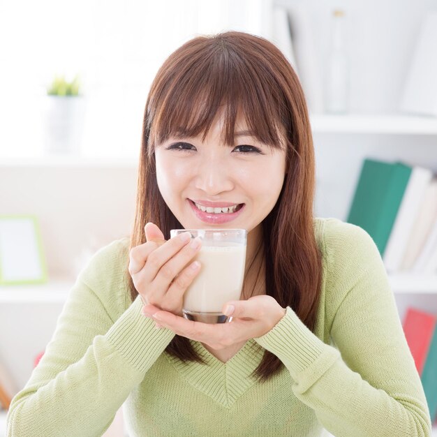 写真 家で飲み物を飲んでいる笑顔の女性の肖像画