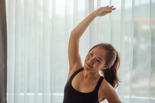 写真 家のカーテンの前で笑顔の若い女性の肖像画