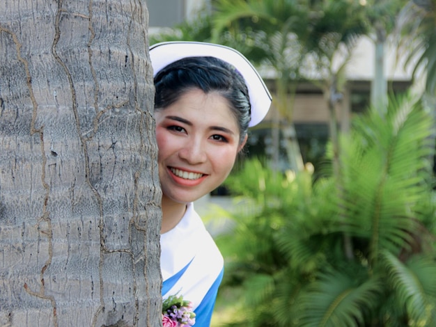 写真 木の幹に笑顔の若い女性の肖像画