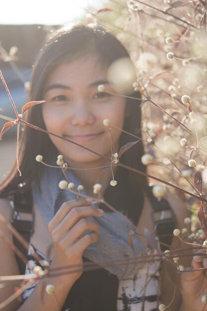 写真 植物を通して見られる笑顔の若い女性の肖像画