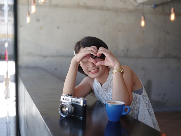 写真 カフェに座っている笑顔の若い女性の肖像画