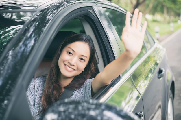 写真 車に座っている笑顔の若い女性の肖像画