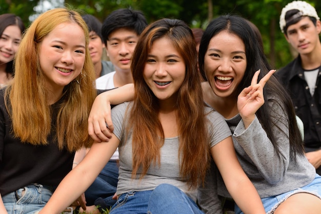 写真 外に座っている笑顔の若い女性の肖像画