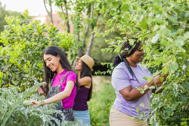 写真 植物に寄りかかって立っている笑顔の若い女性の肖像画