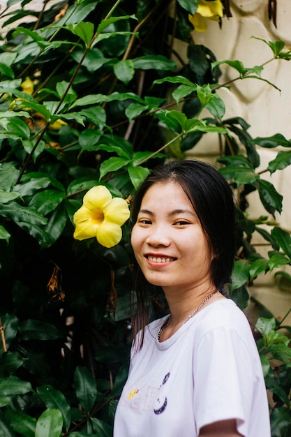 Фото Портрет улыбающейся молодой женщины, стоящей у растения