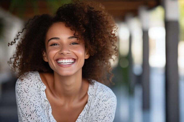 Фото Портрет улыбающейся молодой женщины с кудрявыми волосами, смотрящей в камеру в кафе