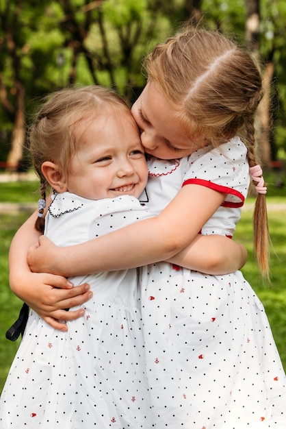 사진 행복한 어린 시절 우정의 개념을 웃고 포옹하는 두 자매의 초상화