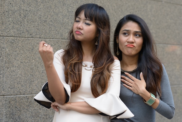 Фото Портрет двух молодых азиатских деловых женщин вместе в городе на открытом воздухе