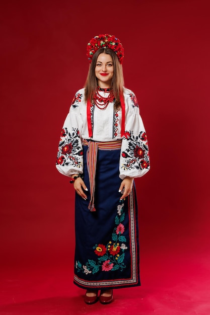 Фото Портрет украинки в традиционной этнической одежде и цветочном красном венке на фоне студии viva magenta украинская национальная вышитая одежда называется вышиванка молитесь за украину