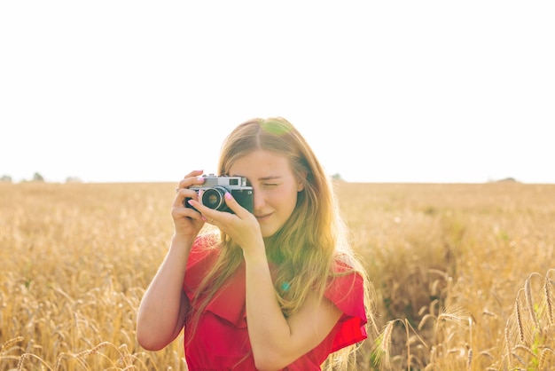 写真 空の向こうのフィールドで写真を撮っている女性の肖像画